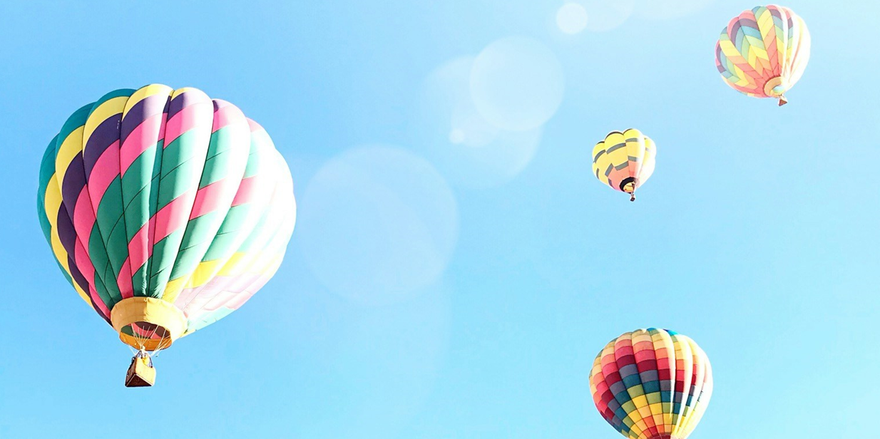 hot air balloons floating in a bright blue sky